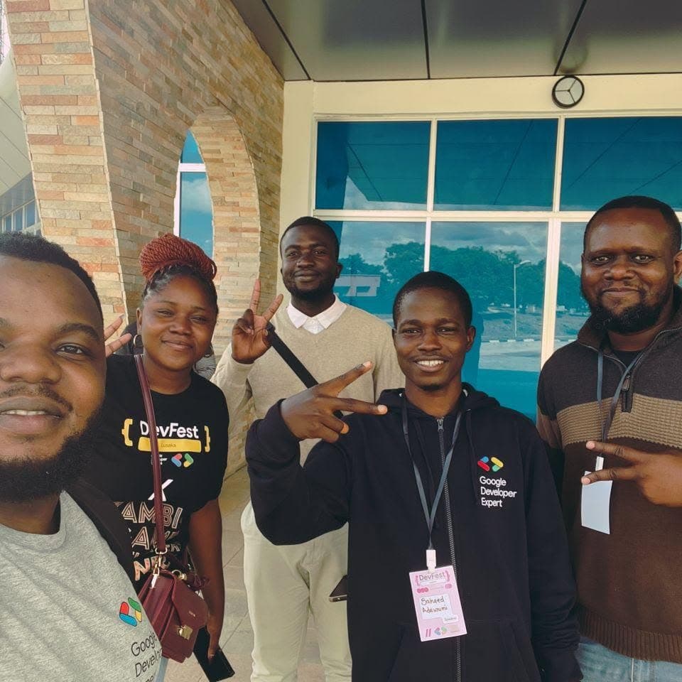 A group selfie of five community members outside a venue
