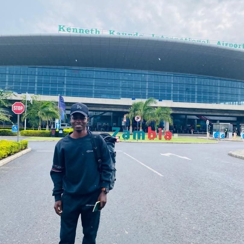 A person standing in front of Kenneth Kaunda International Airport